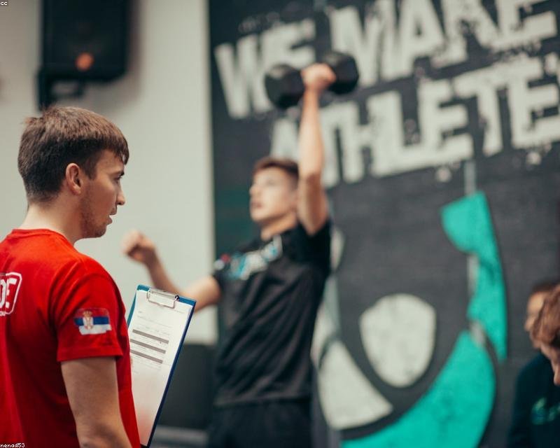 Nick Bowman coaching a client through a bench press in a Midvale gym